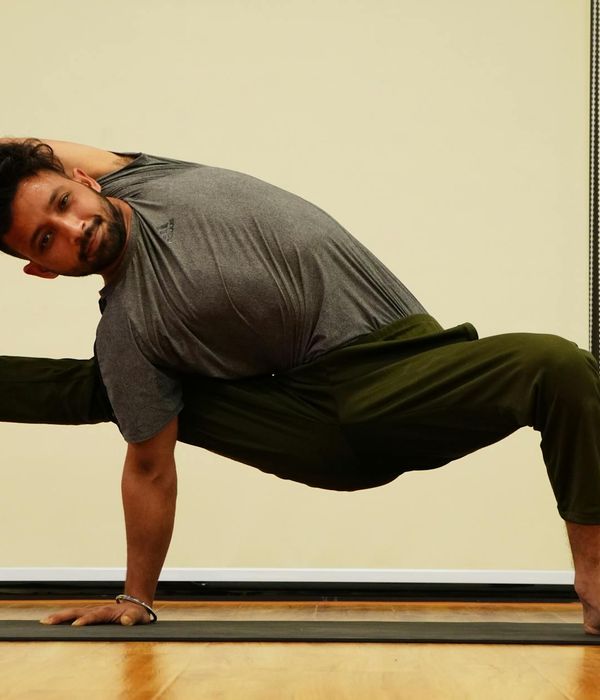 Man holding a challenging balance pose, showcasing core strength and focus.